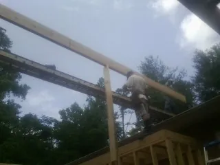 Carpenter setting a ridge beam over a new addition frame — Ice Dam Removal by Roofing Brothers in Laurel Springs