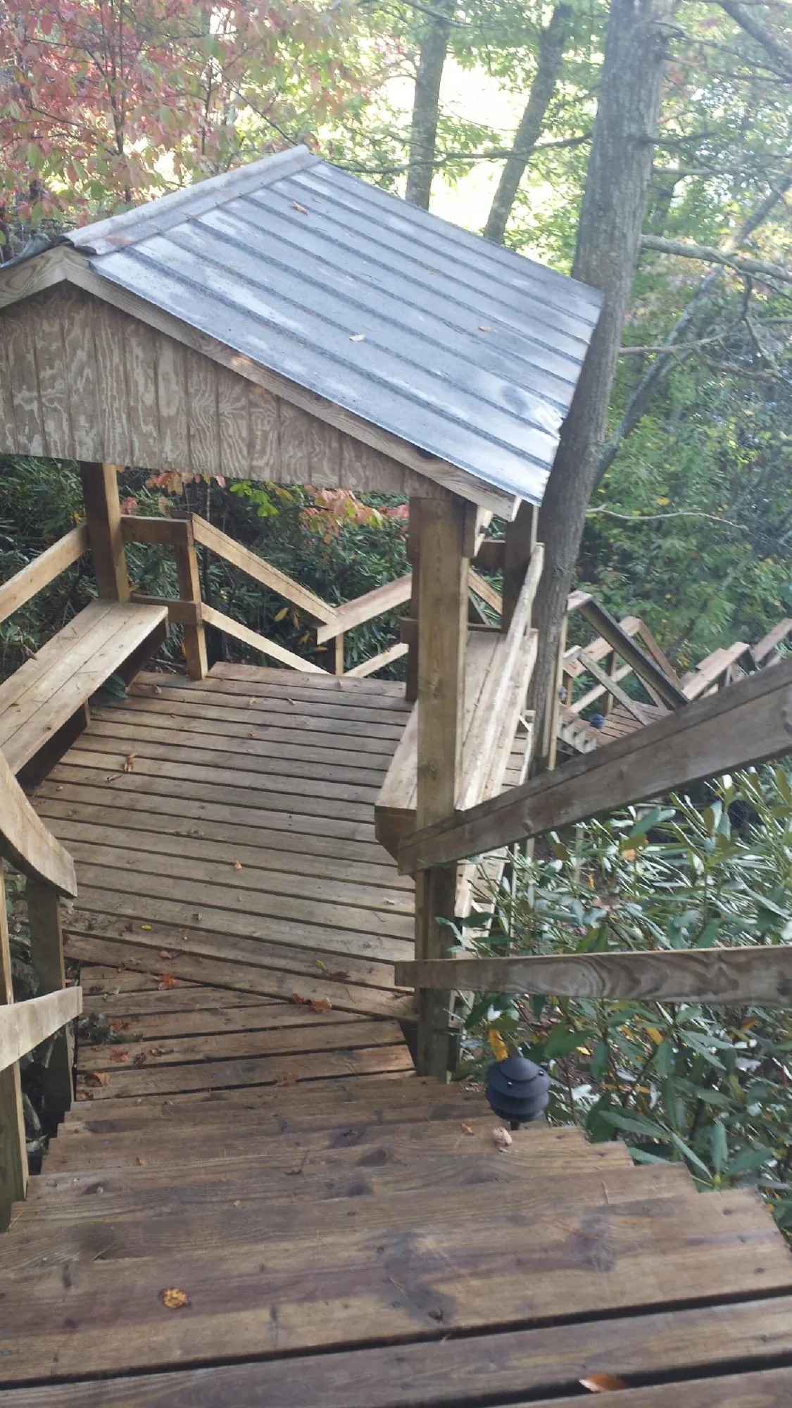 Metal roofed shelter over wooden steps on a wooded walkway — Skylight Repair & Installation work by our crew in Laurel Springs